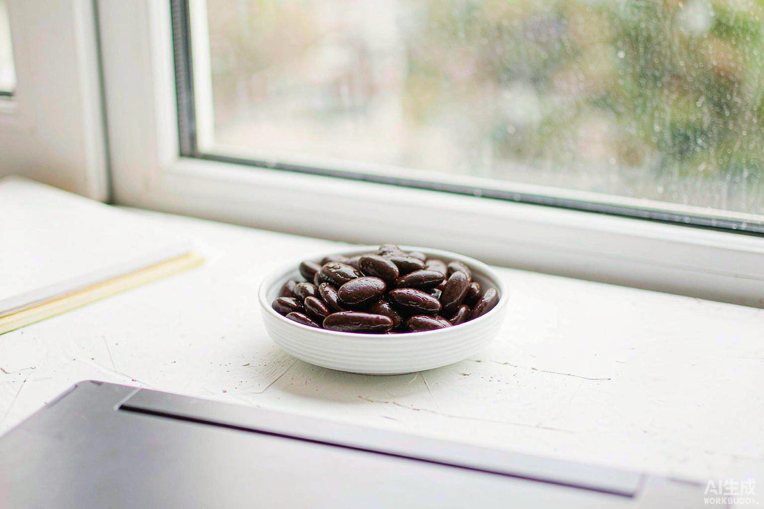 Macro of dark velvet beans in a white ceramic dish on a pale desk beside a laptop edge in soft window light